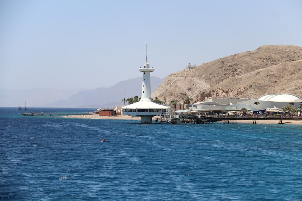 weißes Schiff auf See in der Nähe von Brown Mountain unter blauem Himmel tagsüber