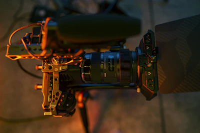 Close-up of a professional video camera with a mounted microphone and lens.