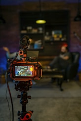 black and orange camera on black tripod