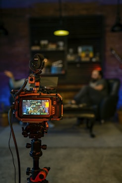 black and orange camera on black tripod