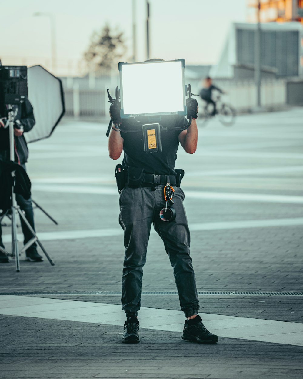 man in black t-shirt and black pants with black backpack walking on pedestrian lane during