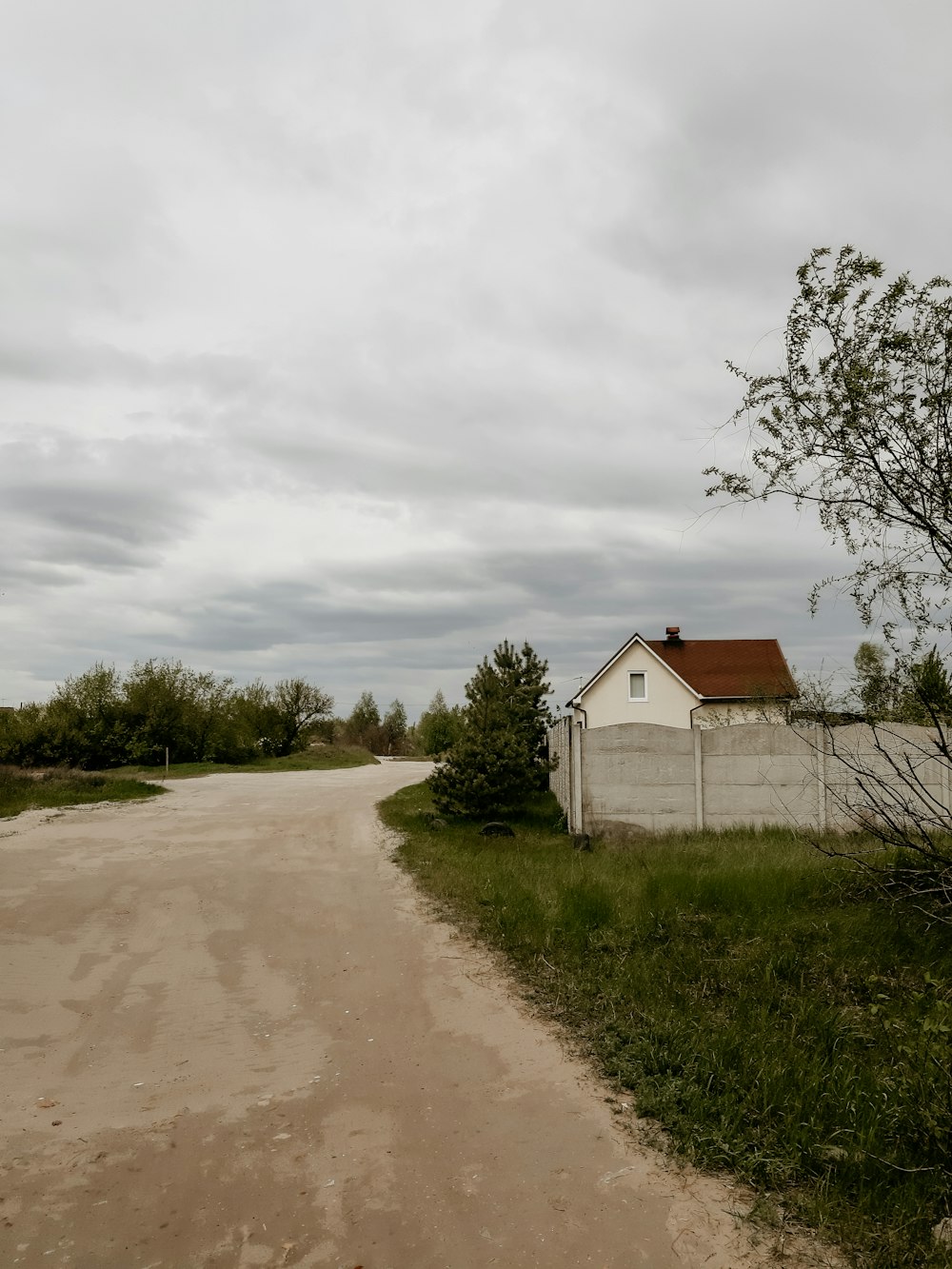 white and brown wooden house near green grass field under white clouds during daytime