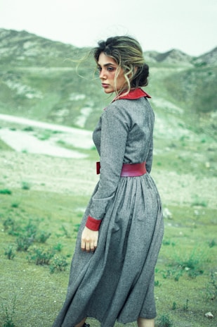 woman in black long sleeve dress standing on green grass field during daytime