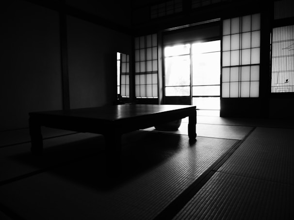 Guests seated in gentle zen yoga poses on tatami mats inside a historic temple room with shoji screens
