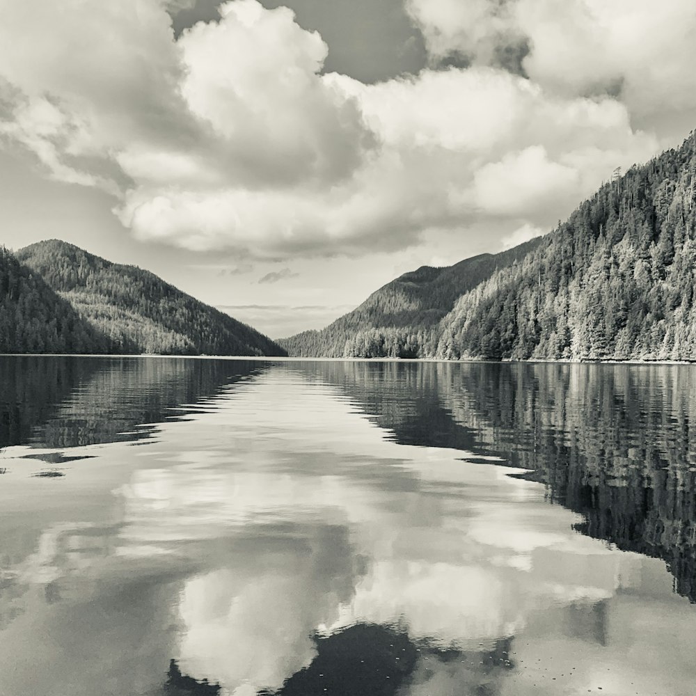 lake near mountain under cloudy sky during daytime