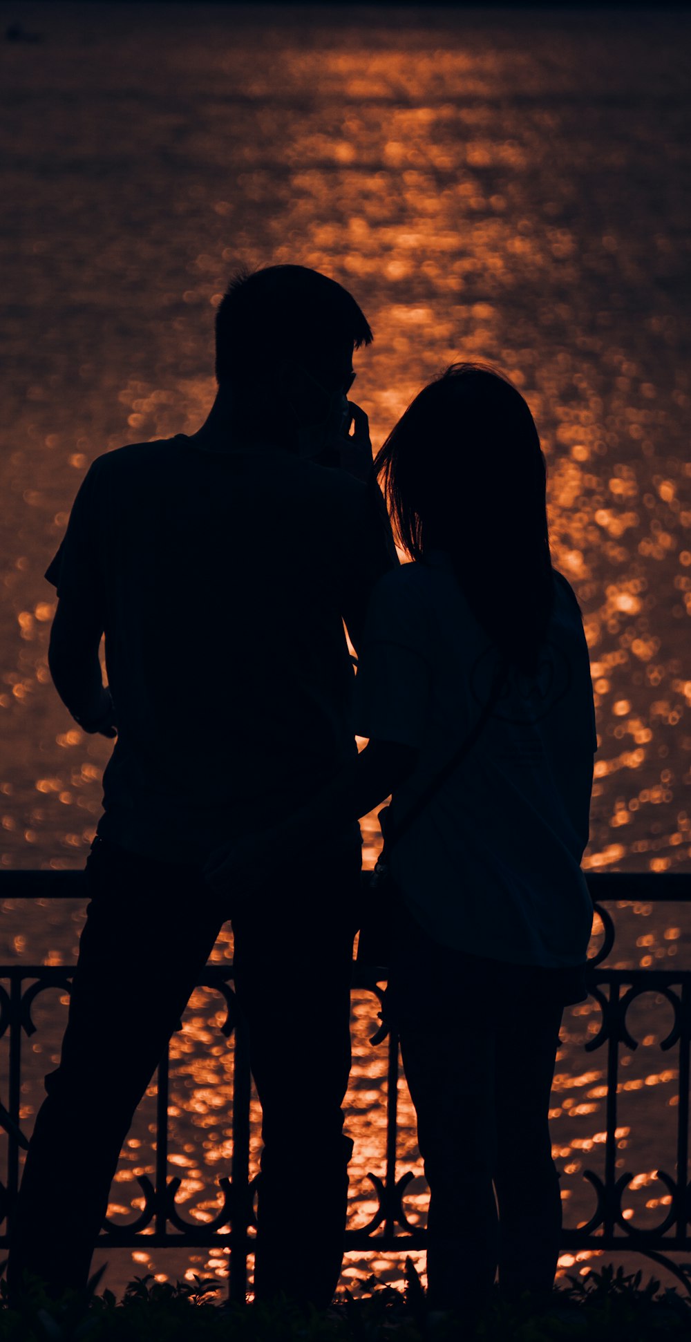 silhouette of man and woman standing during sunset