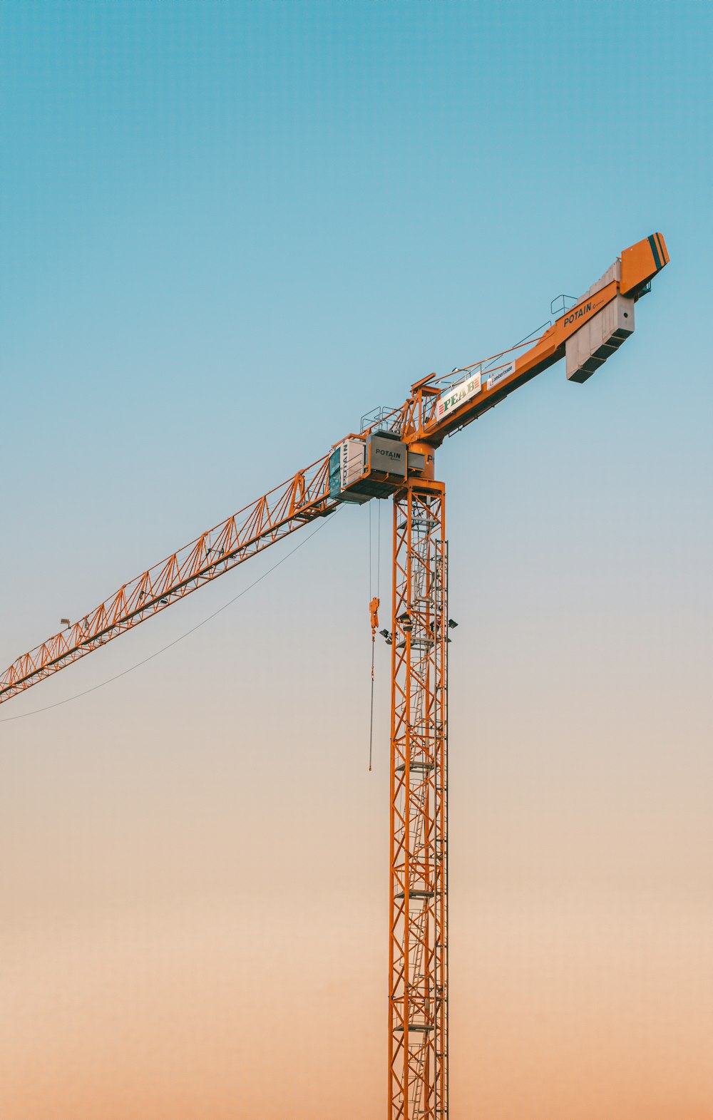 orange crane under blue sky during daytime