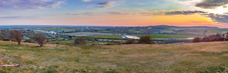A panoramic view of Punjab’s lush fields with the five rivers weaving through the landscape under a golden sunset.