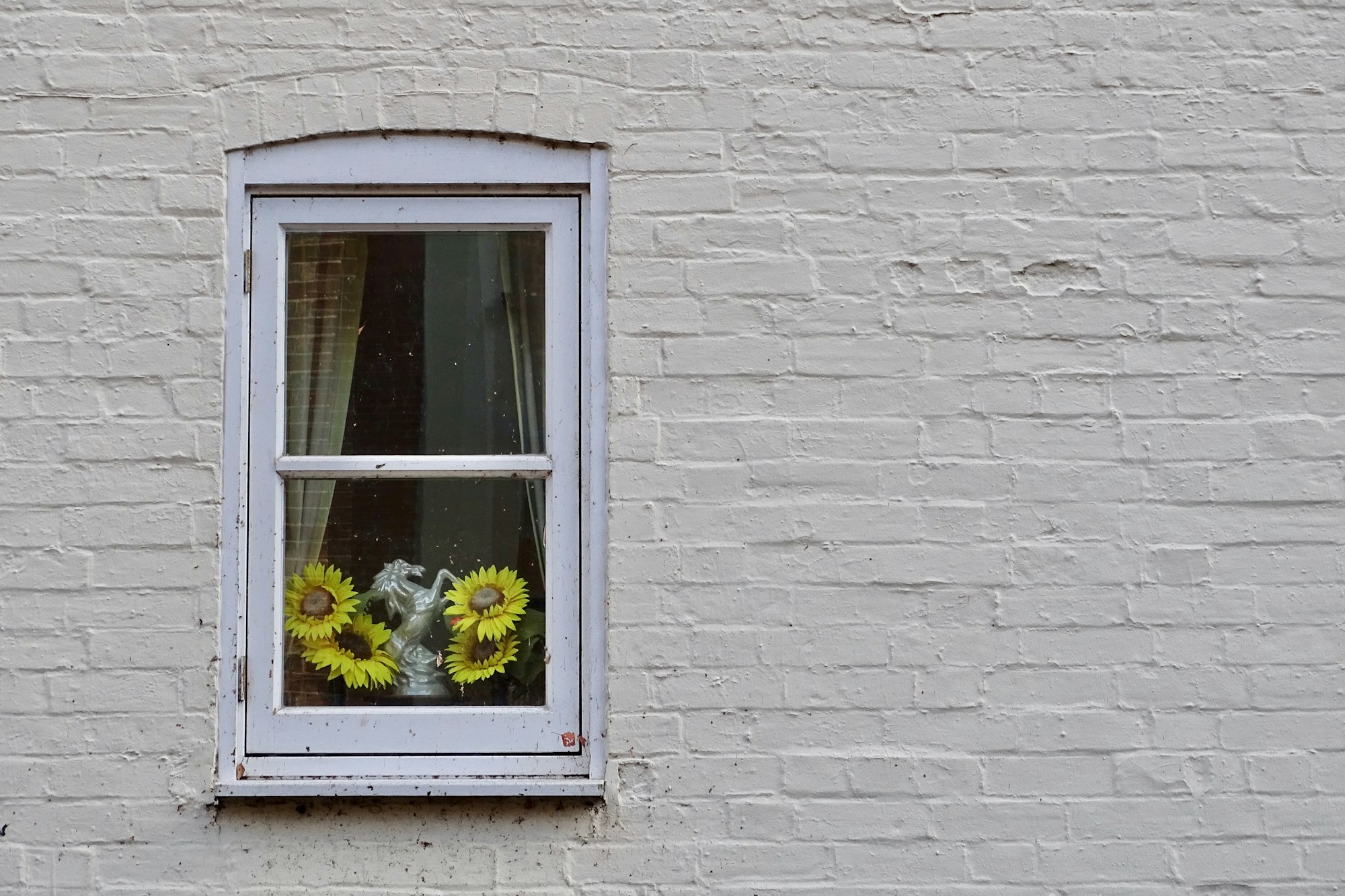 I love this little window seen in Salisbury framing the sunflowers and horse ornament inside.  