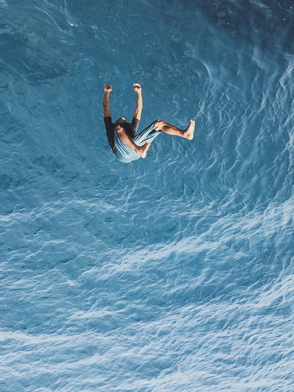 man in black shorts floating on water during daytime