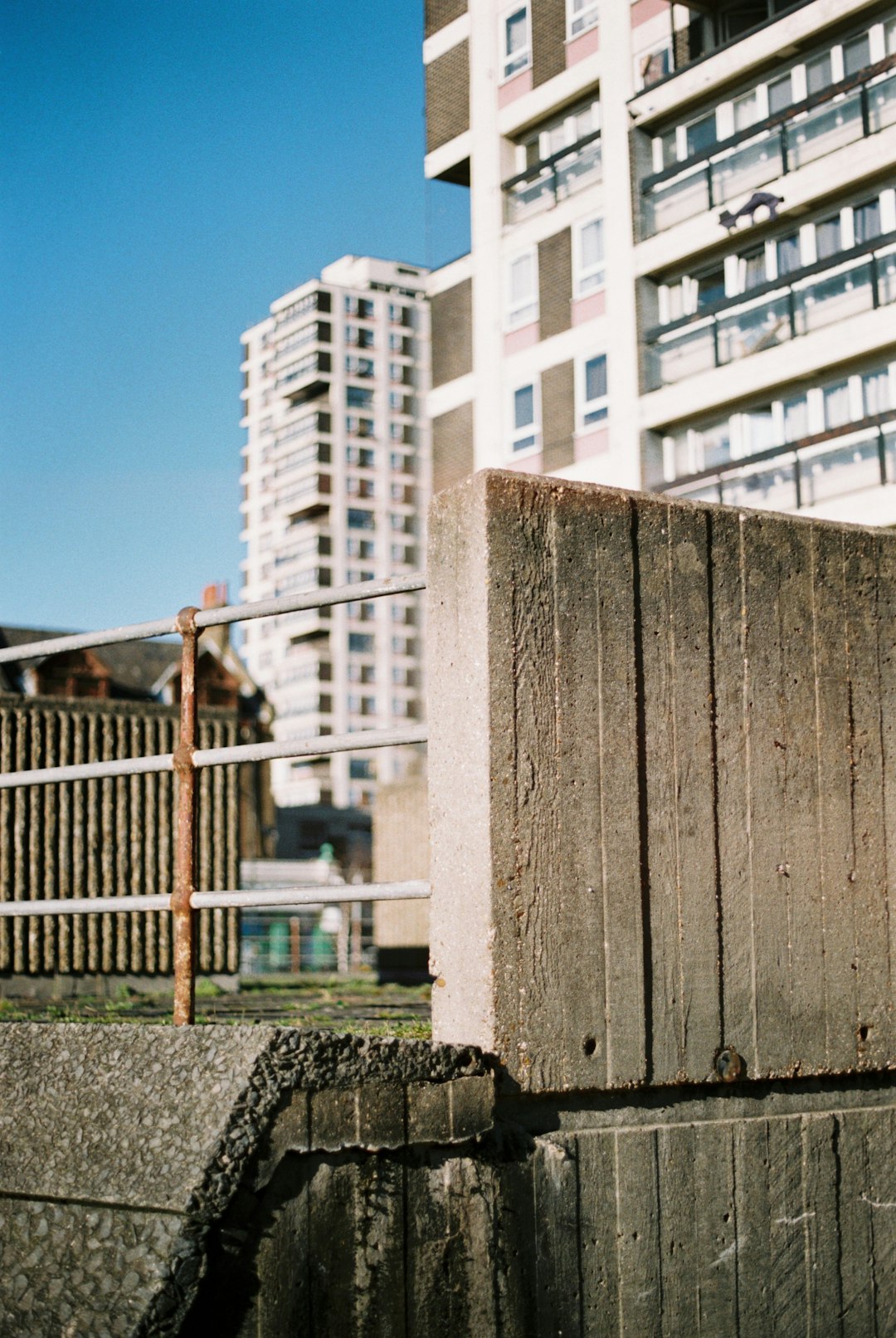 brown wooden fence near white concrete building during daytime