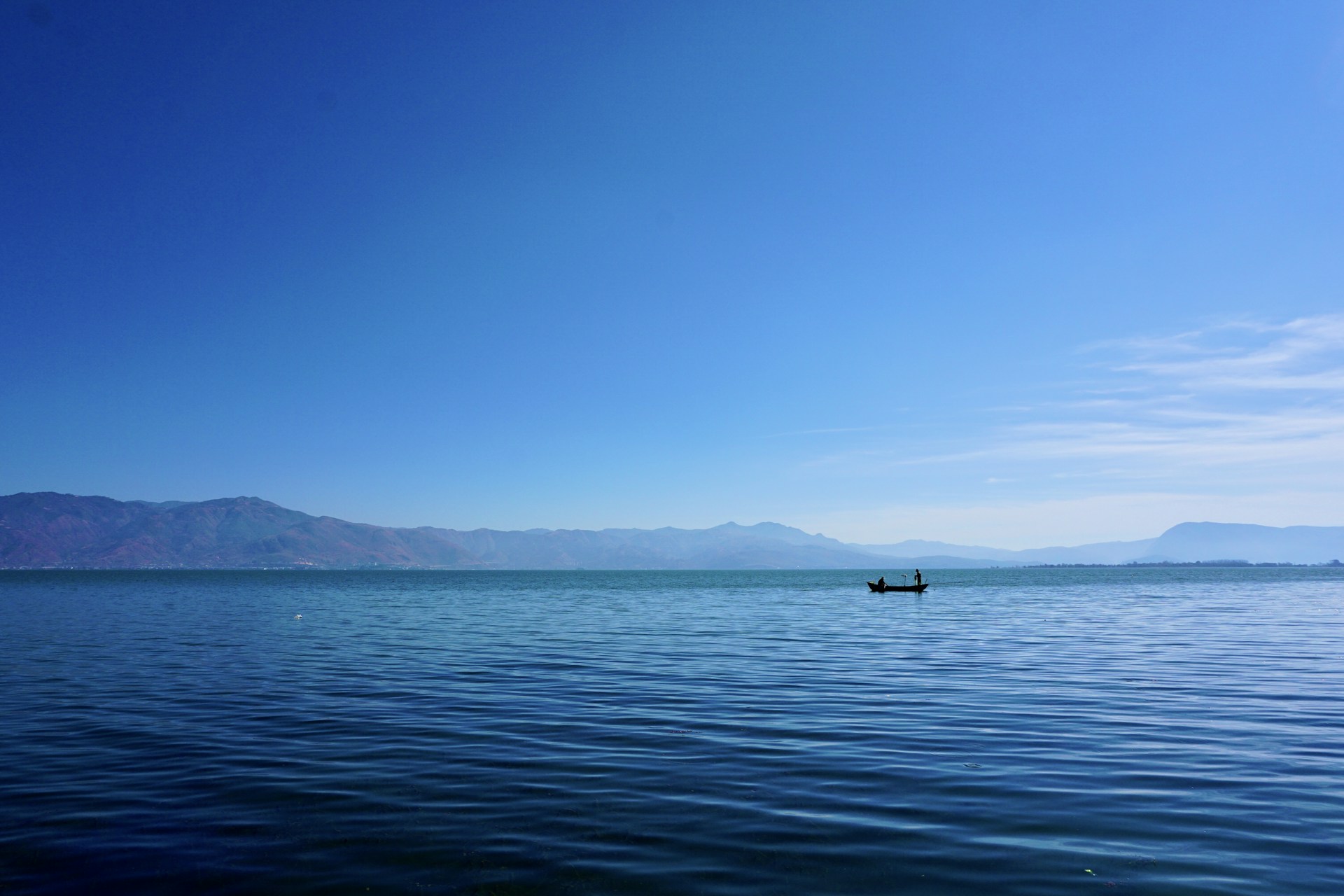 boat on sea near mountain during daytime