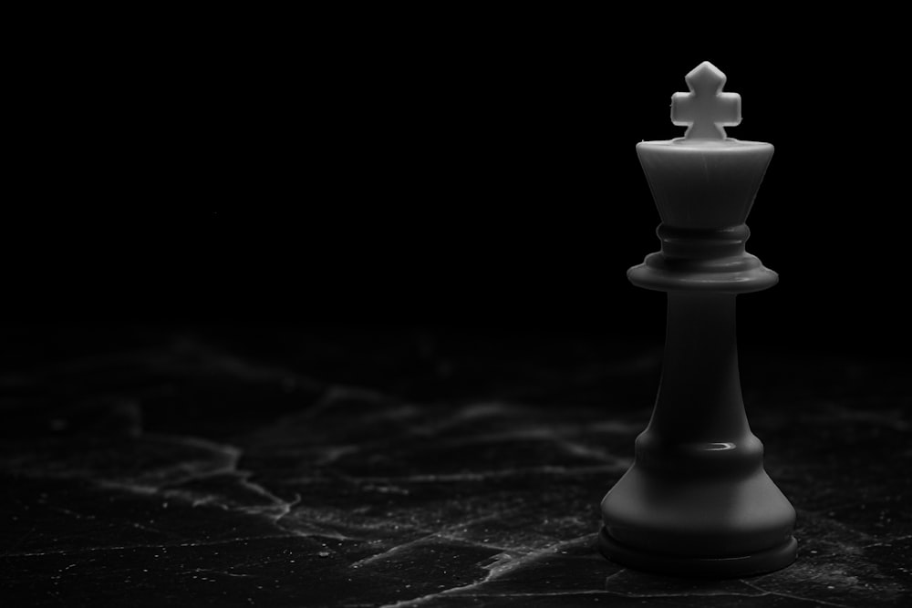 white chess piece on black surface