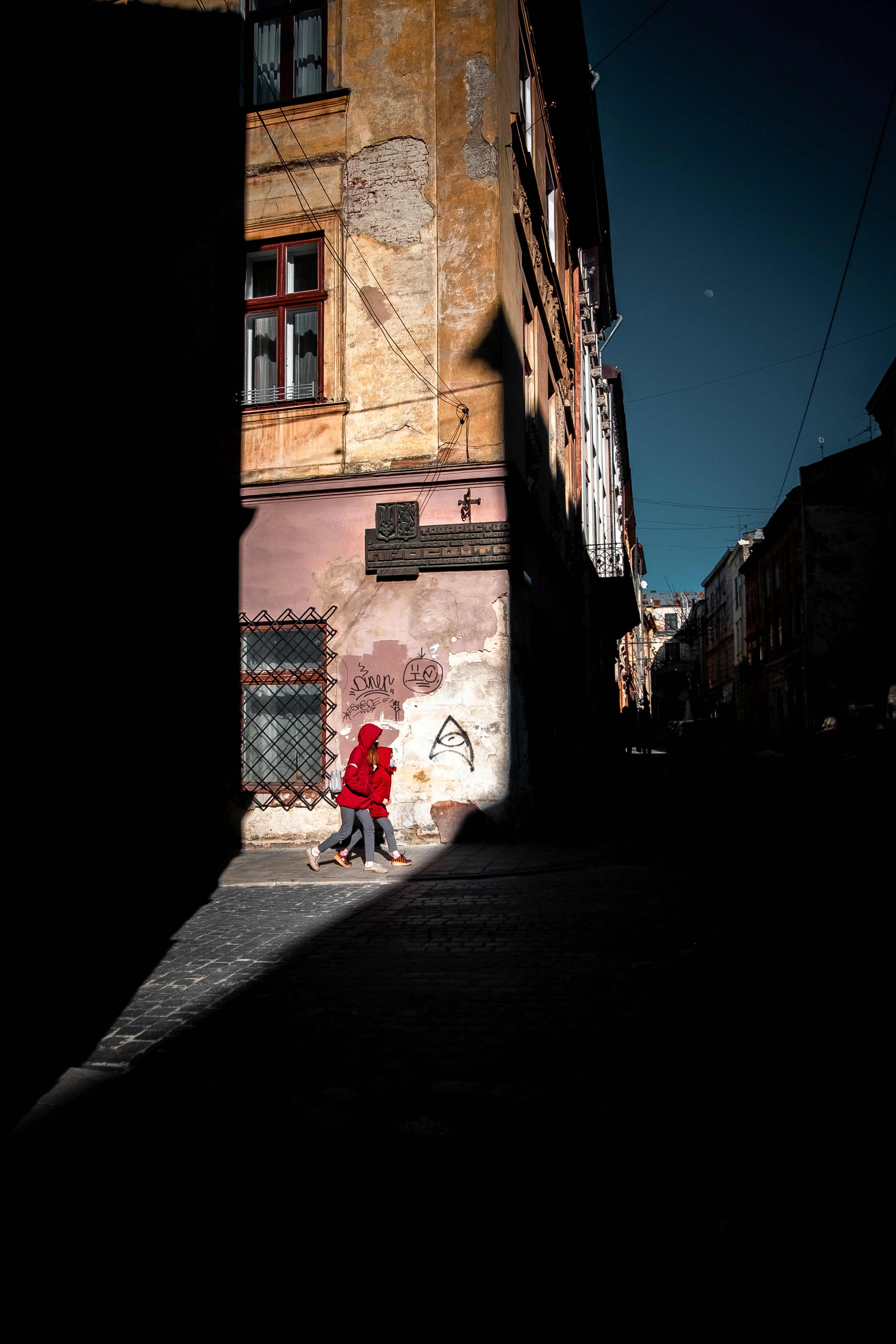 person in red jacket walking on street during daytime