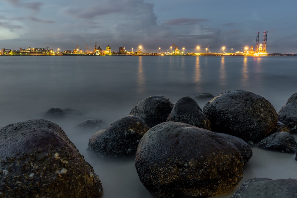 black rocks on sea shore during sunset