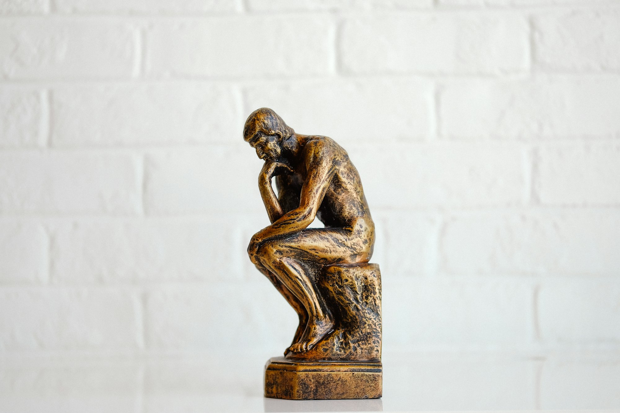 Statue of a person sitting thinking