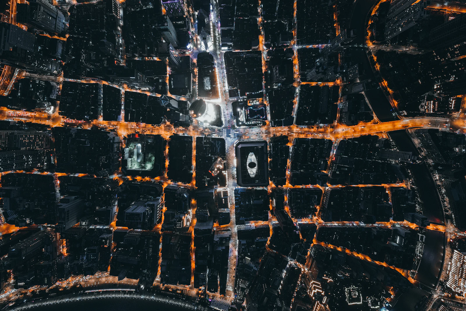 Top-down aerial view of a city street grid lit at night