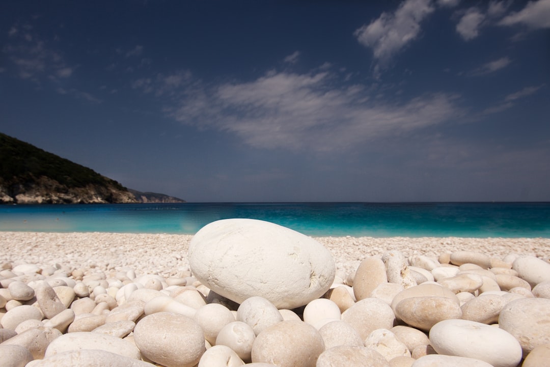 white and gray stones on white sand beach during daytime