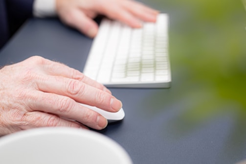 person holding white computer keyboard