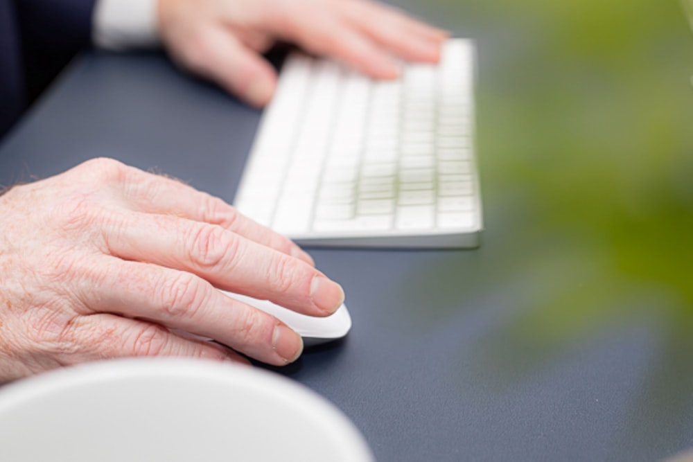 person holding white computer keyboard