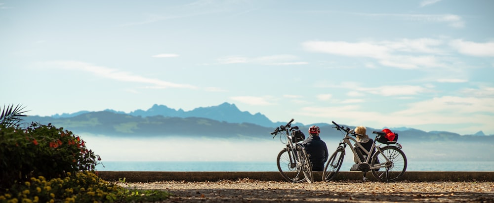 black bicycle parked on brown dirt near body of water during daytime