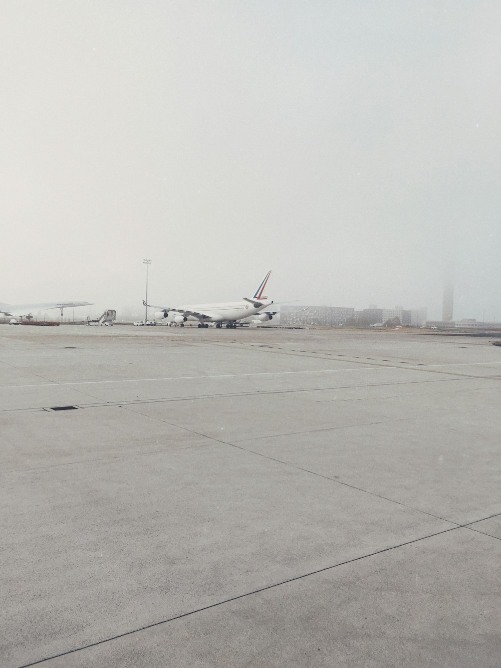 white airplane on gray concrete ground during daytime