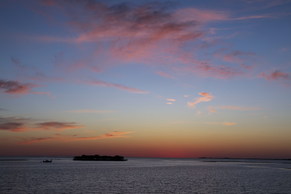 body of water under orange and blue sky during sunset