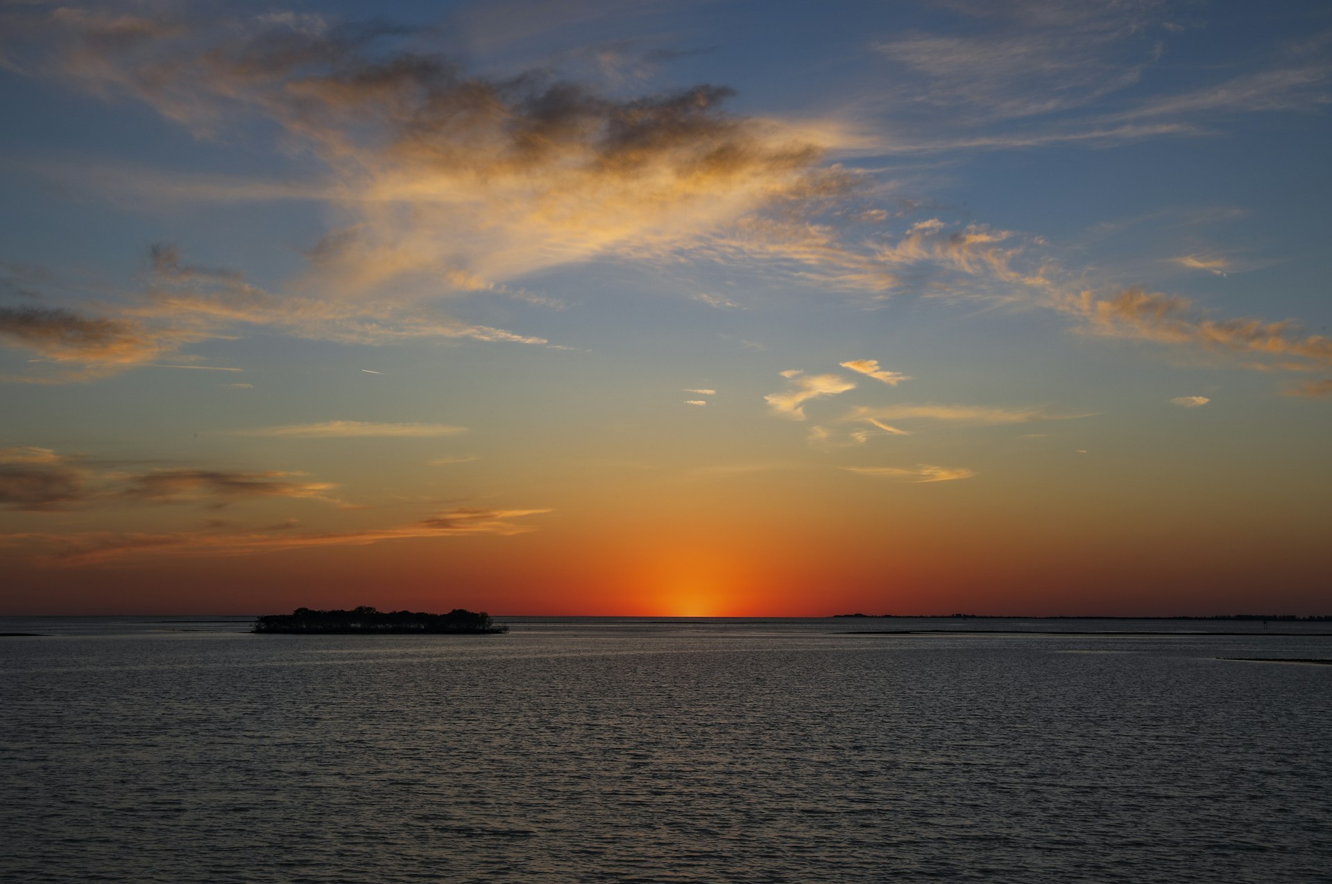 body of water under cloudy sky during sunset
