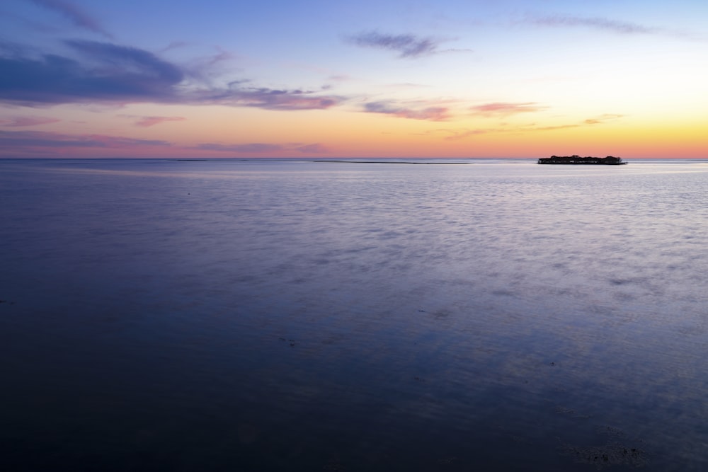 body of water under blue sky during sunset