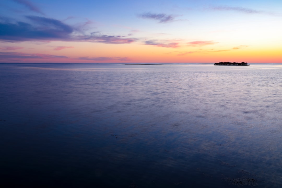 body of water under blue sky during sunset