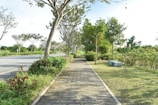 Lush landscaped green spaces with benches and walking paths at Neoliv Plots.