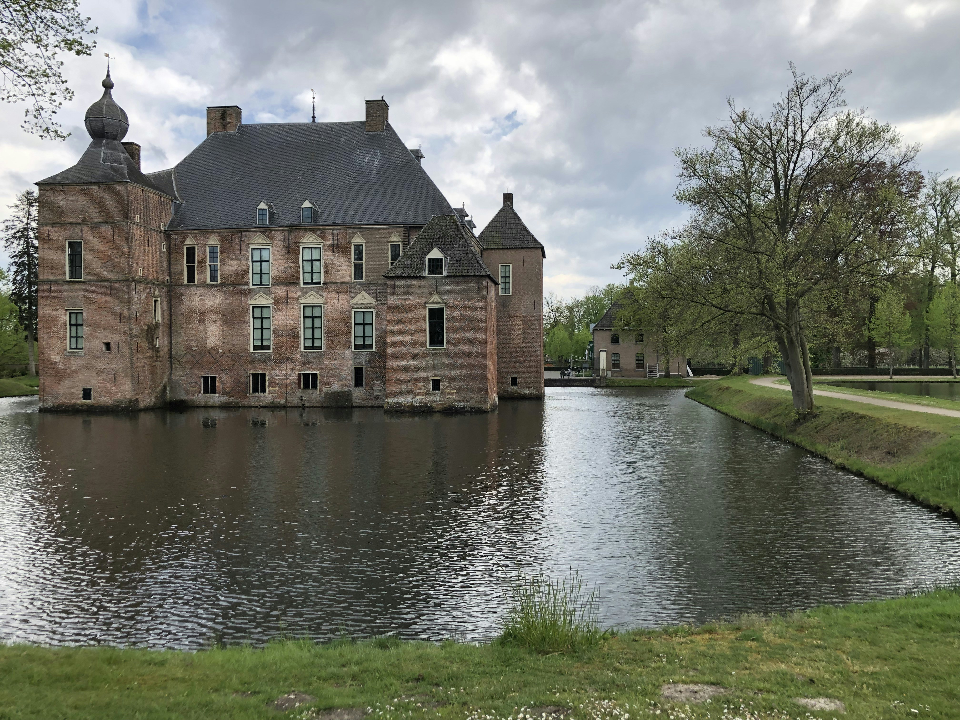 Braunes Betongebäude am Fluss unter bewölktem Himmel tagsüber