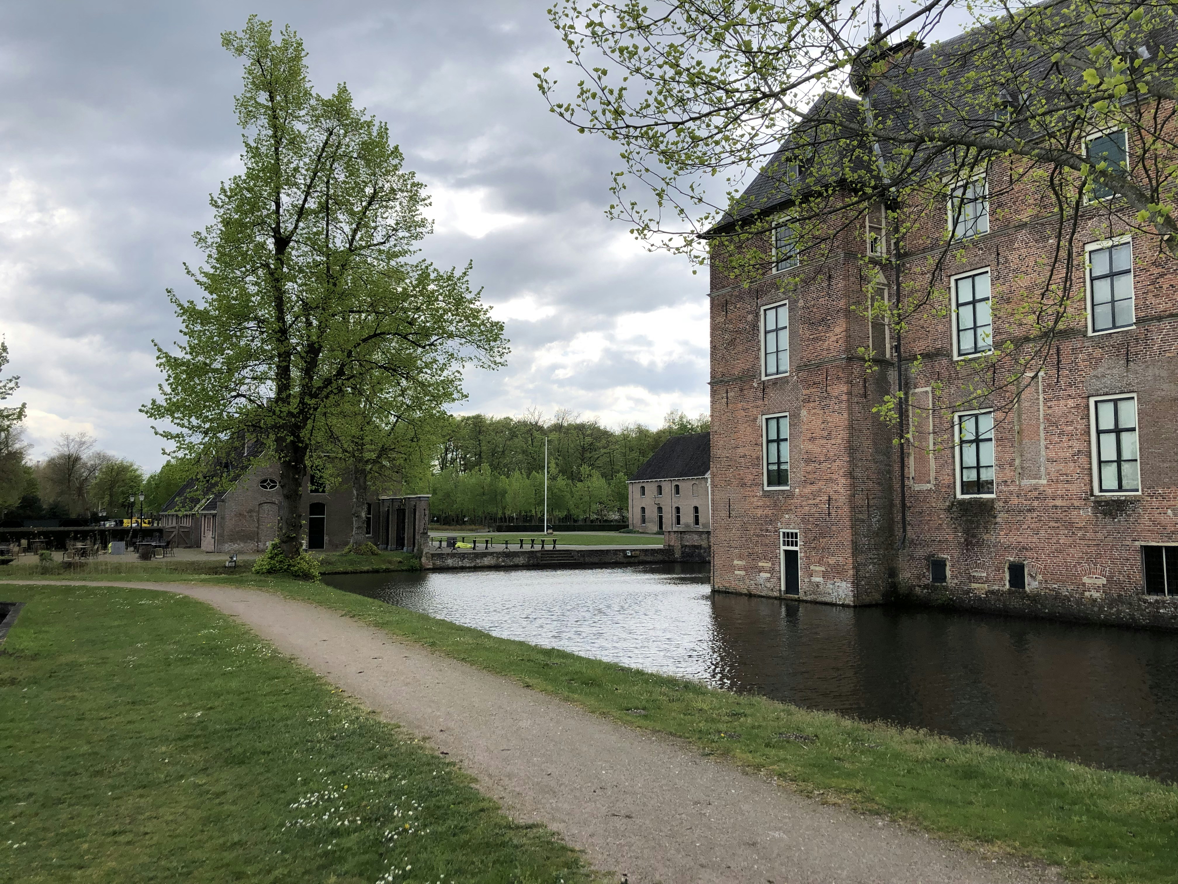 edificio in cemento marrone vicino al fiume sotto nuvole bianche durante il giorno