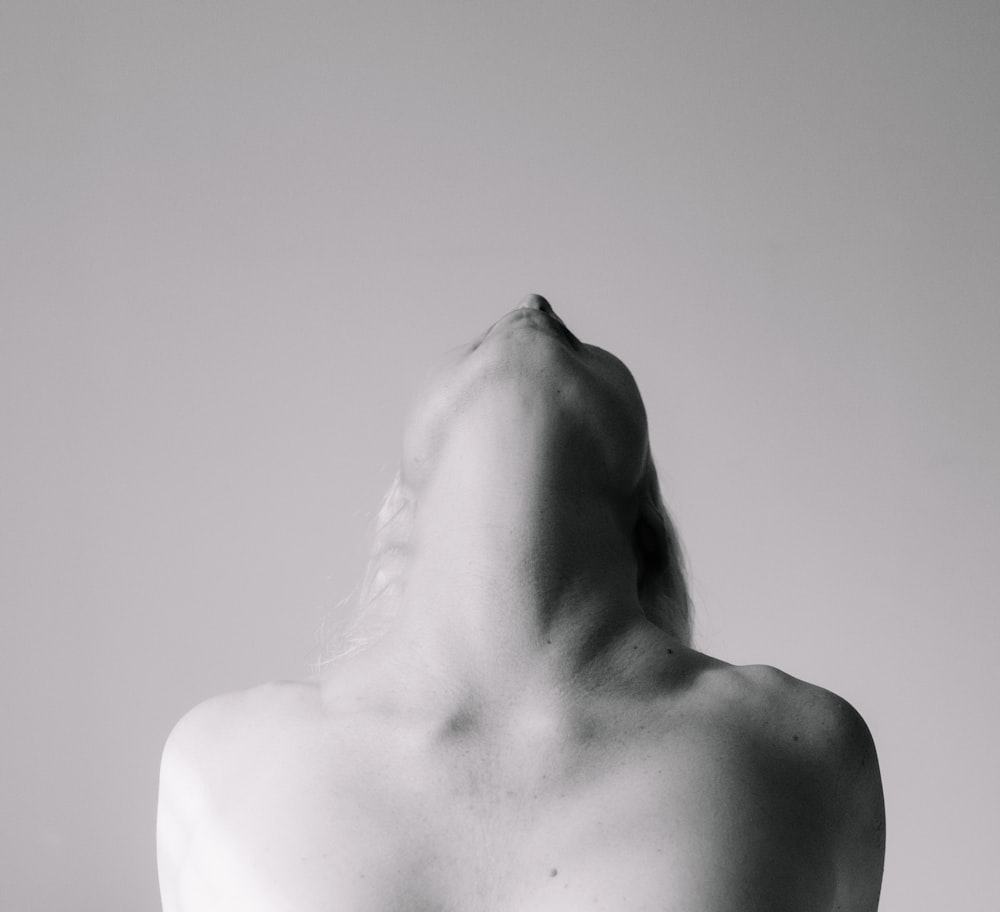 estátua branca do corpo humano na fotografia em escala de cinza