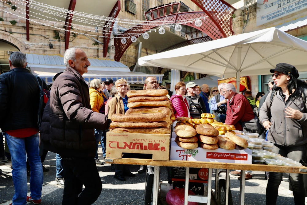 man in black jacket standing in front of bread