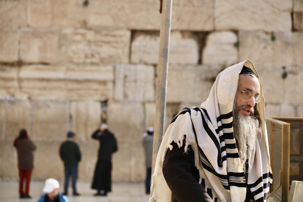 man in black and white stripe hoodie standing near people during daytime