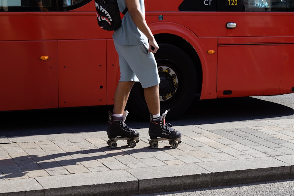 woman in white dress and black shoes standing beside red bus during daytime