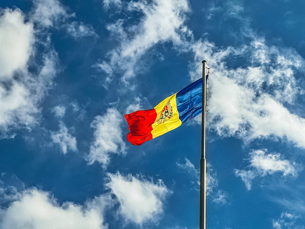 bandera roja, azul y amarilla bajo el cielo azul durante el día