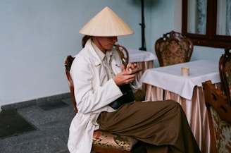 Smiling traveler receiving her Vietnam e-visa confirmation on a smartphone at a cozy cafe.