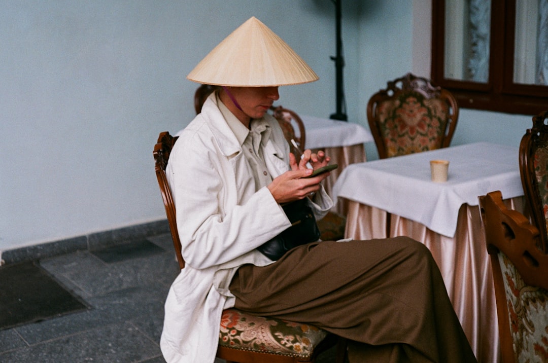 woman in white robe sitting on brown wooden chair