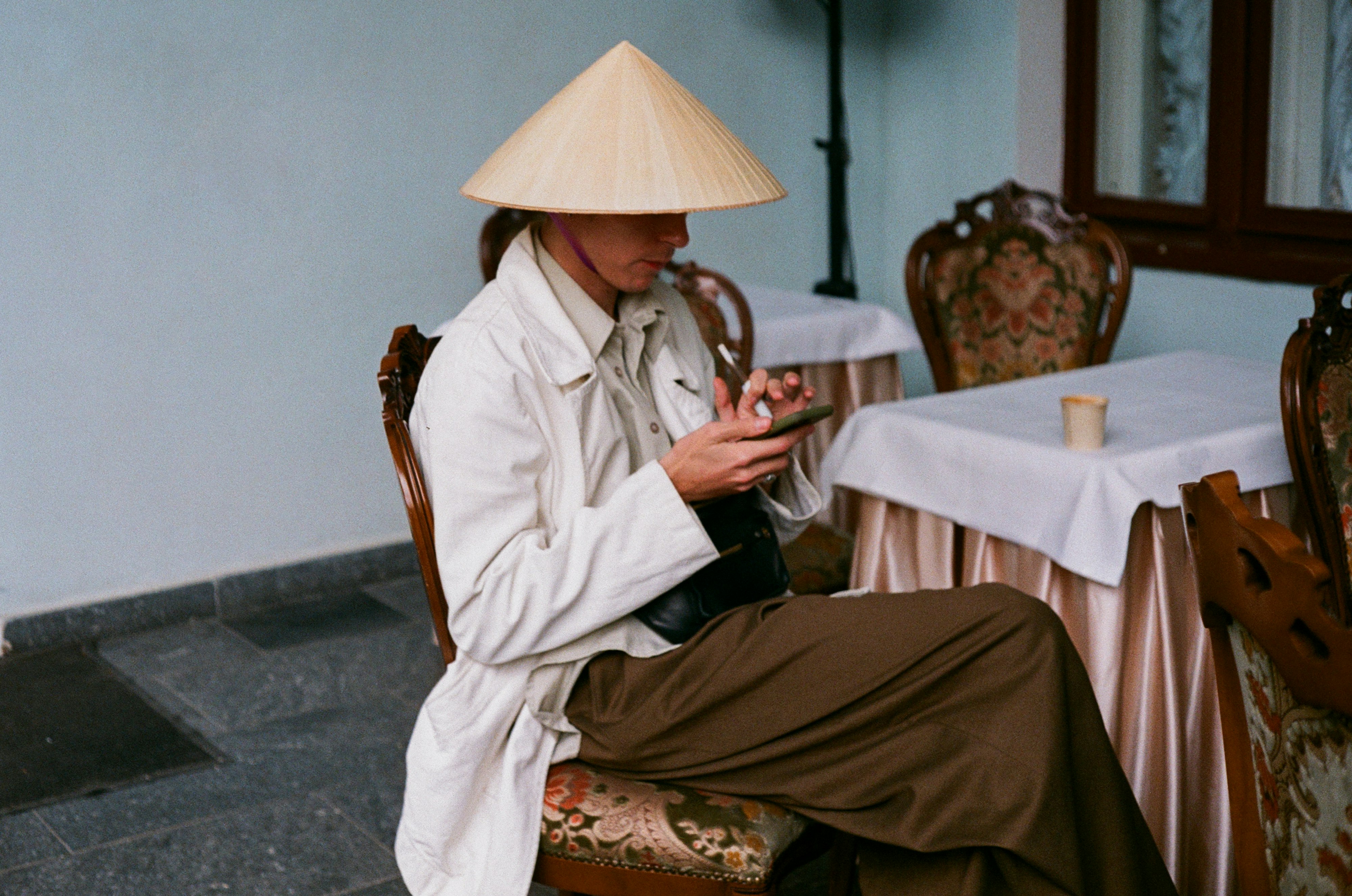 woman in white robe sitting on brown wooden chair