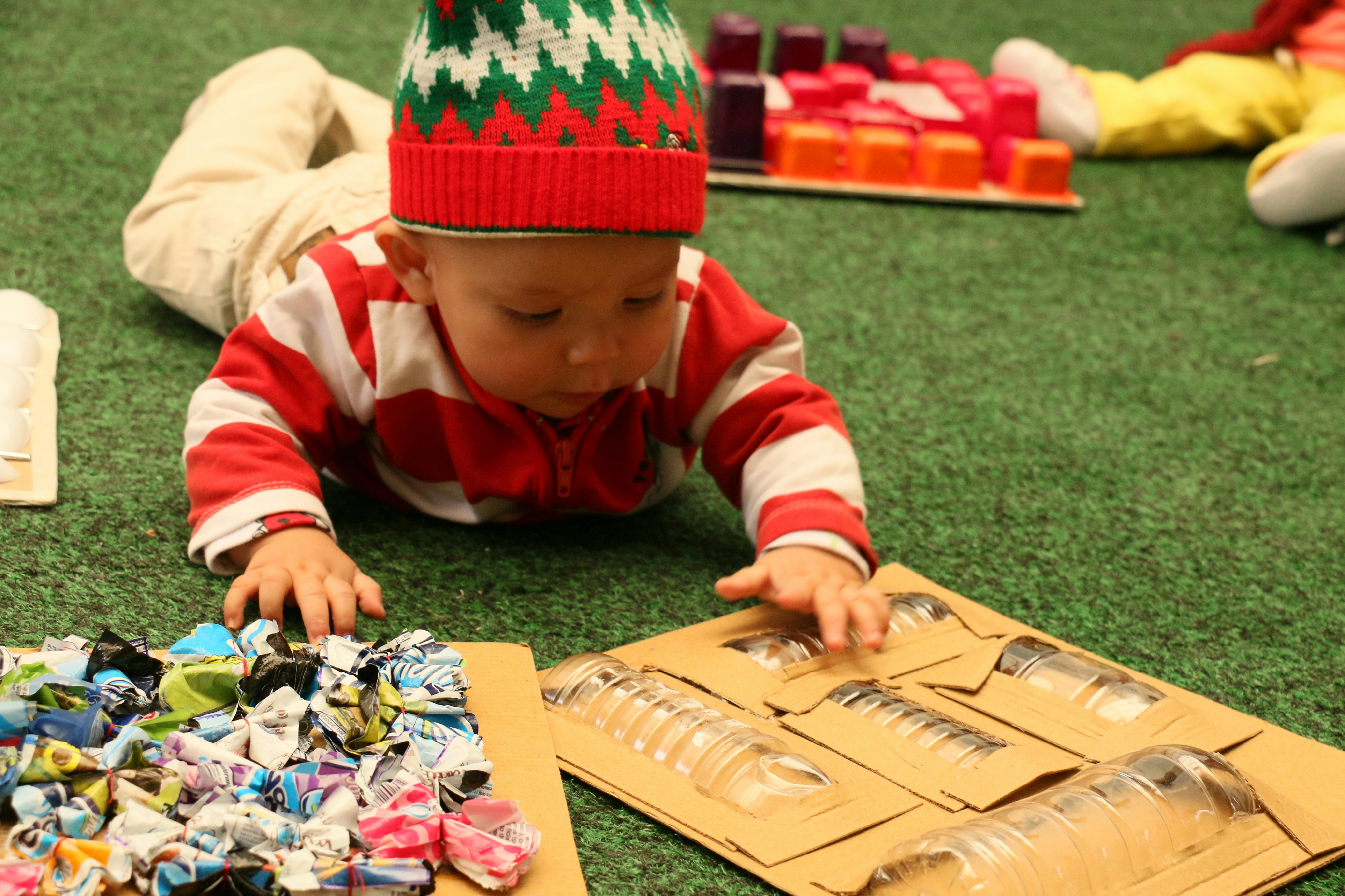 child in red and white striped sweater playing chess