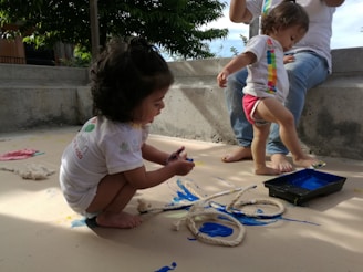 girl in white t-shirt sitting on sand during daytime