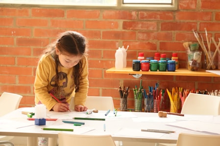 woman in brown jacket writing on white paper