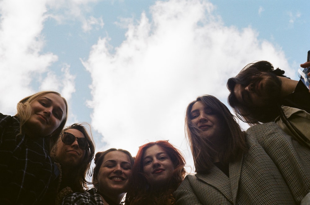 group of people taking photo under white clouds during daytime