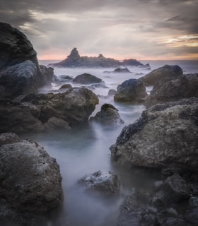 rocky shore with ocean waves during sunset
