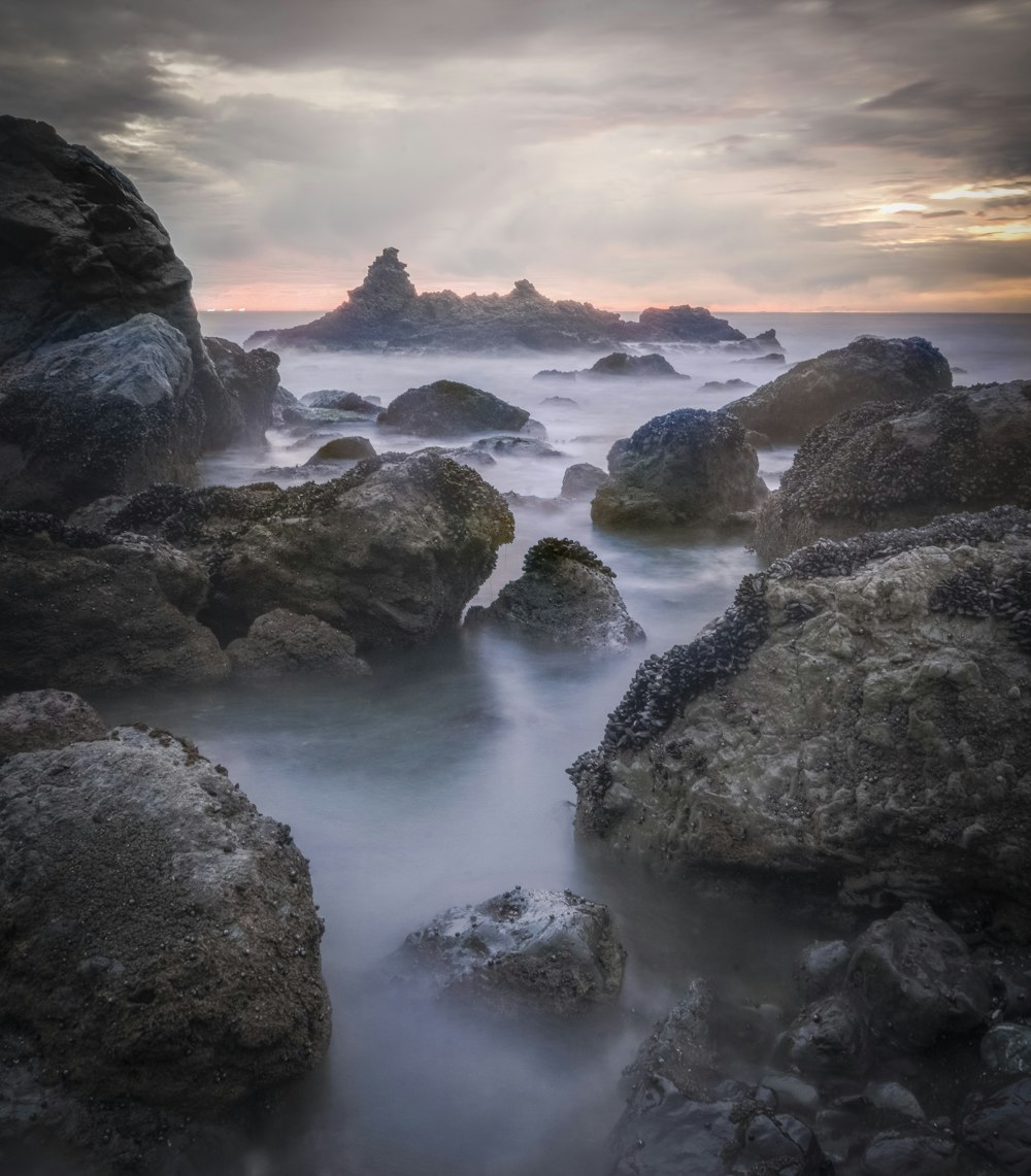 rocky shore with ocean waves during sunset