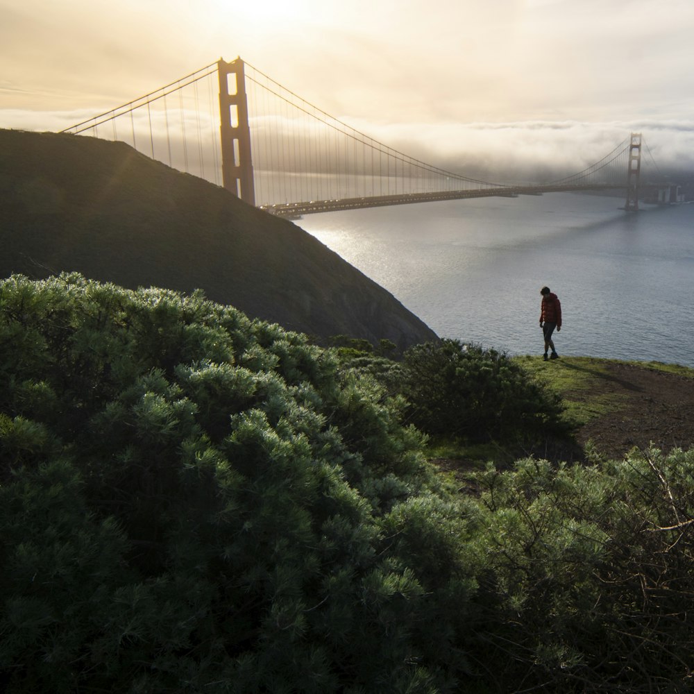 person standing on green grass near golden gate bridge during daytime