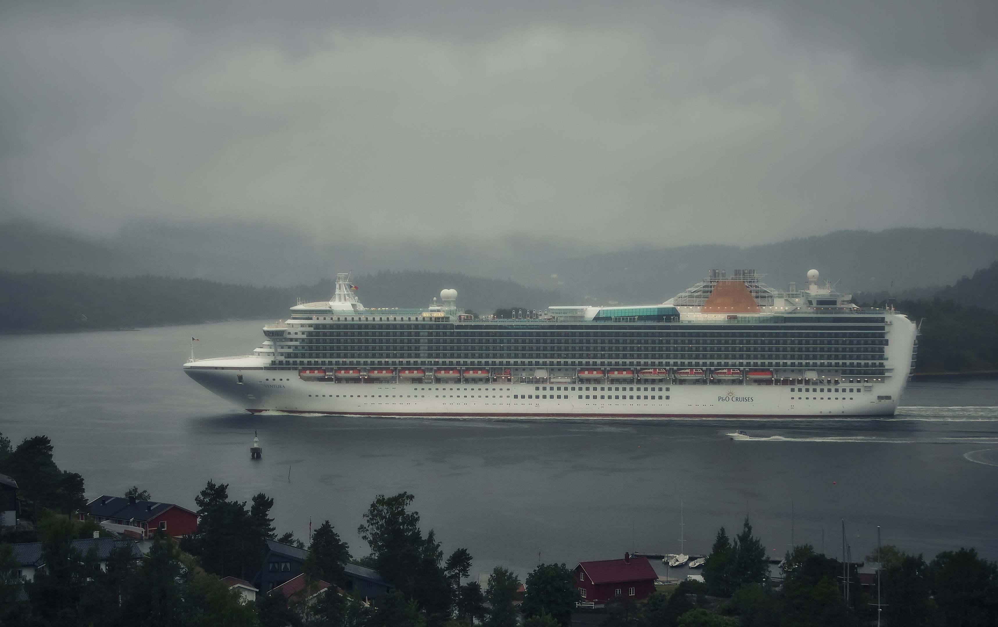 white cruise ship on sea under gray sky