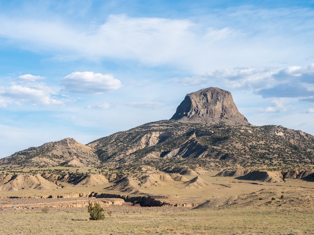 brown and gray mountains under white clouds and blue sky during daytime